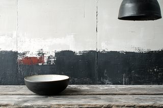 Bowl On Wooden Table Against Painted Wall
