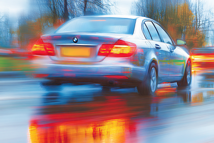 Car Speeding on Wet Road