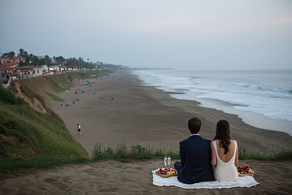 Romantic Beach Picnic at Dusk: Couple on Cliff Overlooking Ocean