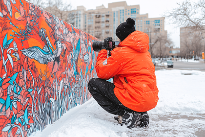 Photographer Capturing Street Art in Winter