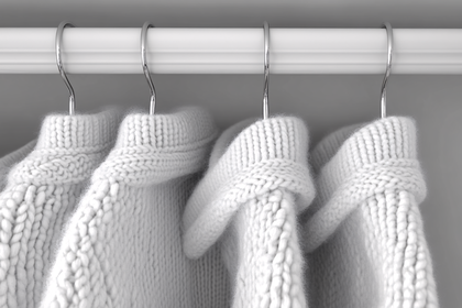 White Knitted Sweaters Hanging On A Rack