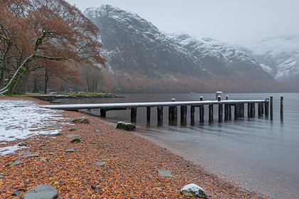 Winter Lake Scene with Pier and Snowy Mountains