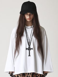 Young Woman in White Shirt with Cross Necklace and Black Cap